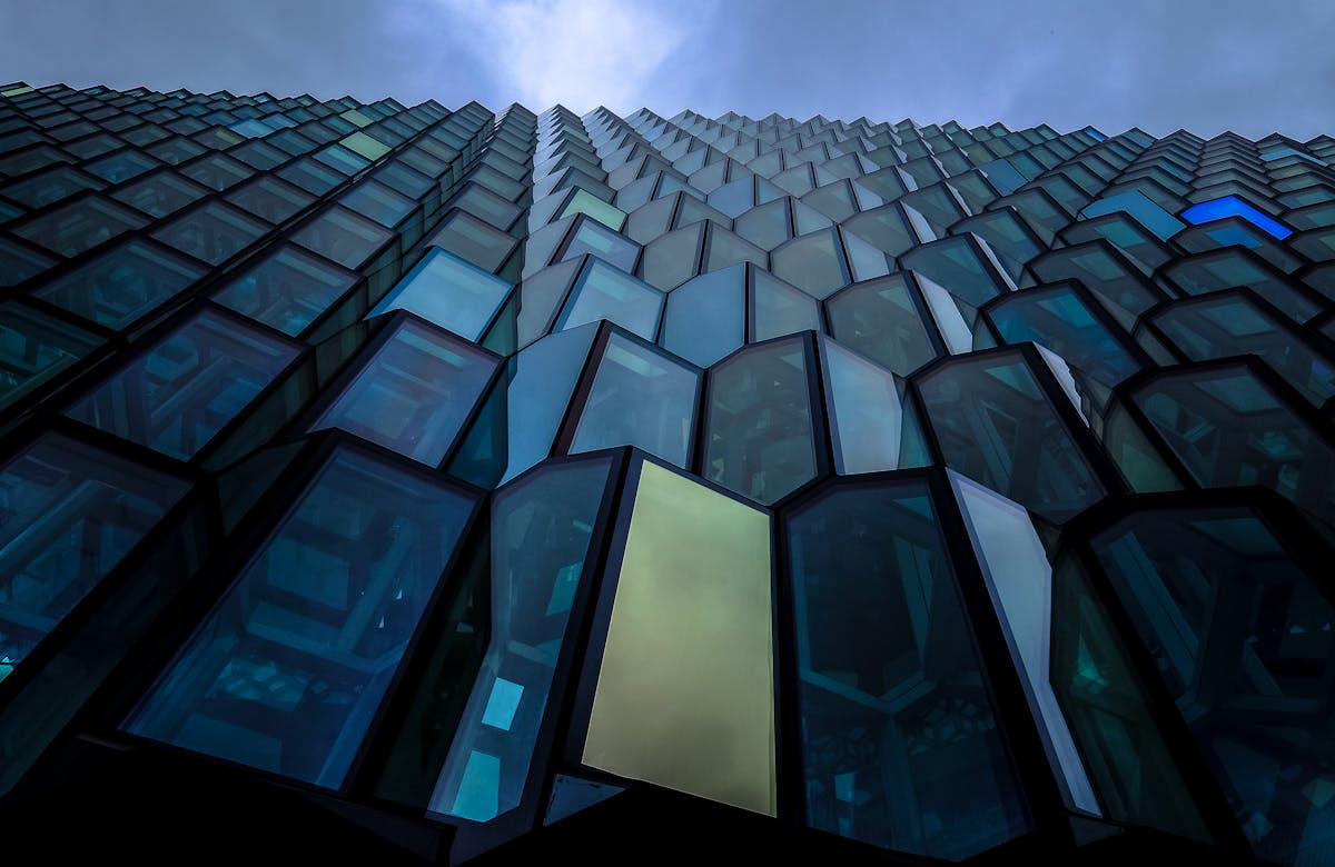 Striking view of a modern building's glass facade with geometric patterns and reflections.