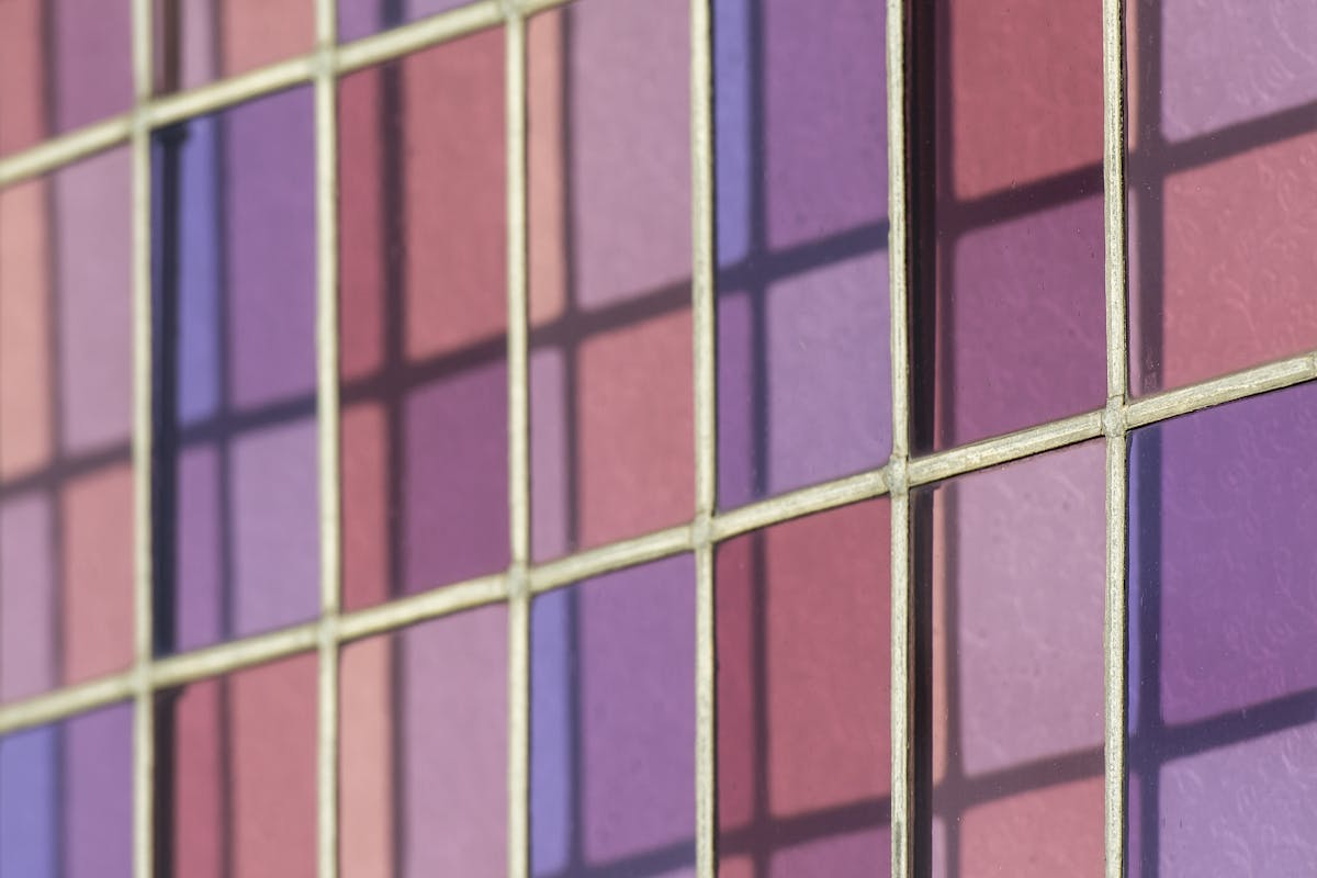 Vibrant close-up of stained glass showcasing shades of pink and purple.